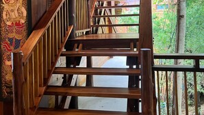 A wooden staircase leading to a covered area with a view of greenery outside. - Viking Nature Resort (Ko Phi Phi)
