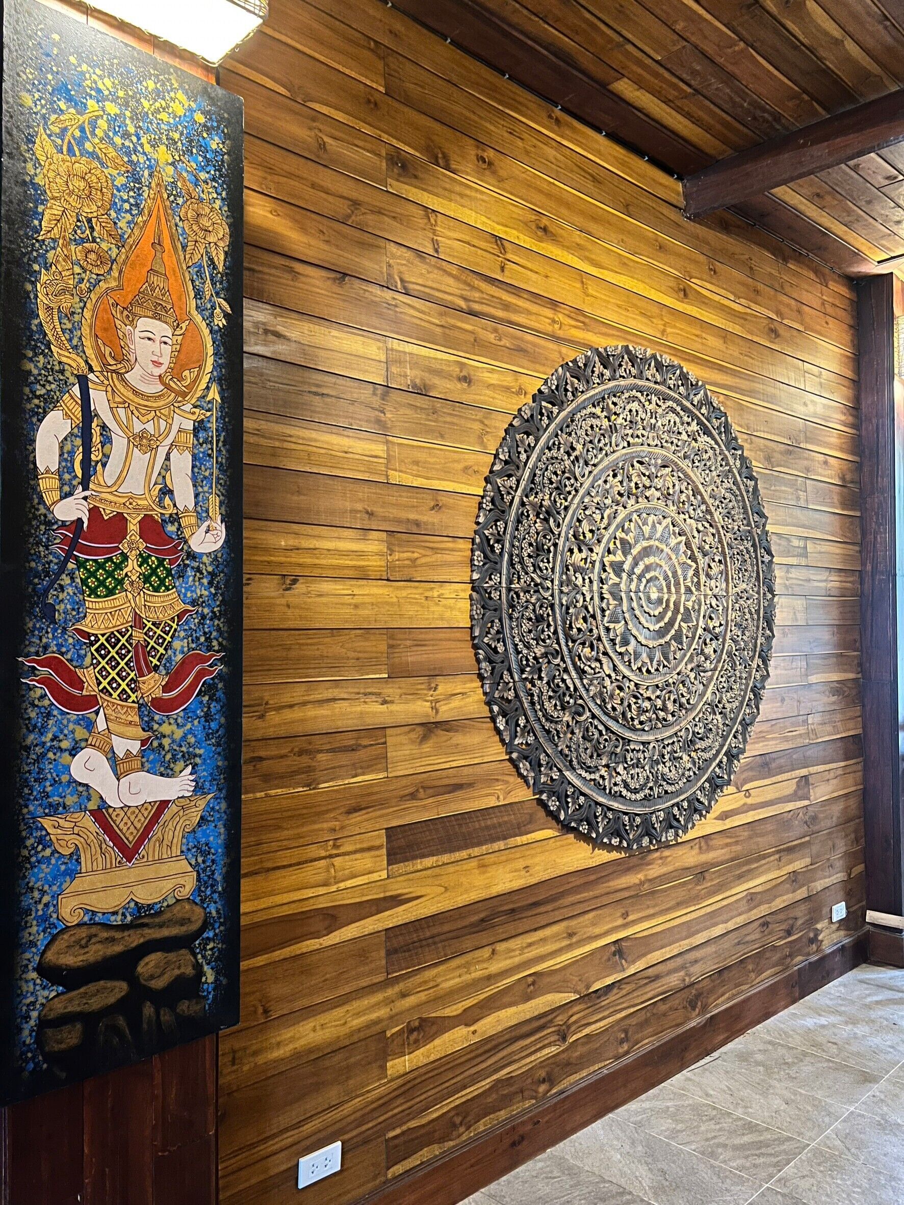 Un mur en bois orné d’un grand élément décoratif circulaire et d’un tableau aux couleurs vives.