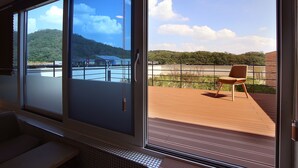 Una habitación con amplias puertas correderas de vidrio que dan a una terraza exterior con una silla.