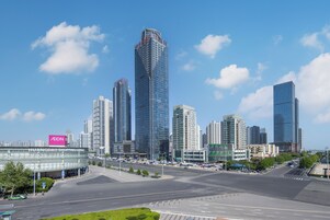 Un paisaje urbano con modernos rascacielos, un centro comercial y un cielo despejado.