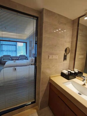 A modern bathroom with a large mirror, a sink, and a vanity. - Oak Chateau Dalian (Dalian)