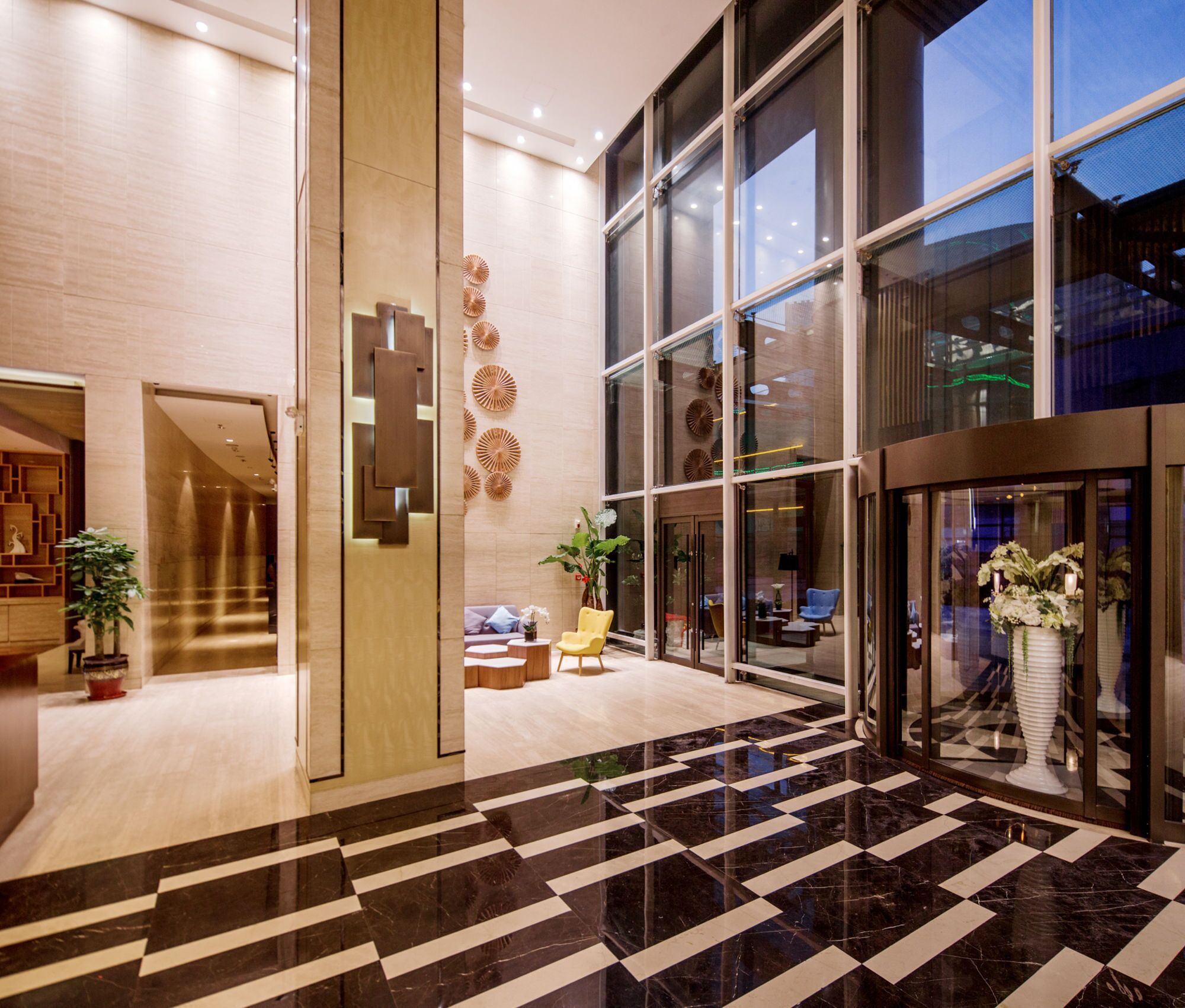 A modern lobby with a checkered marble floor, large windows, and a reception desk.