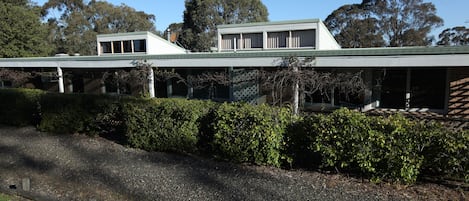 A modern building with a flat roof and a covered walkway.
