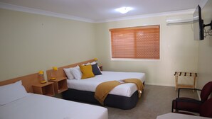 A hotel room with two single beds, a desk, a chair, and a window with blinds. - Country Roads Motor Inn Gayndah Qld (Gayndah)