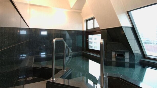 A modern interior with a glass floor, metal railings, and a view of the city through a large window. - Urban Hotel Tokyo Fuchu-Higashiguchi (Fuchu)