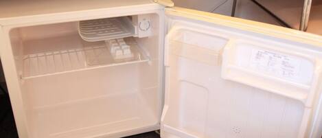 An open refrigerator with a freezer compartment on the left and a main compartment on the right.