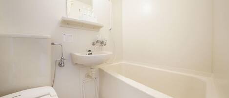 Un baño pequeño y blanco con inodoro, lavabo y bañera.