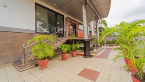 A building entrance with a staircase, potted plants, and a covered area. - Treebo Shivam Inn Near Singapore Mall (Lucknow)