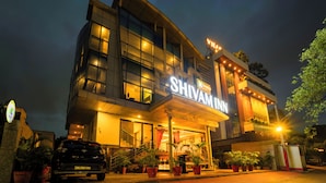 A modern hotel with a prominent sign reading "SHIVAM INN". - Treebo Shivam Inn Near Singapore Mall (Lucknow)
