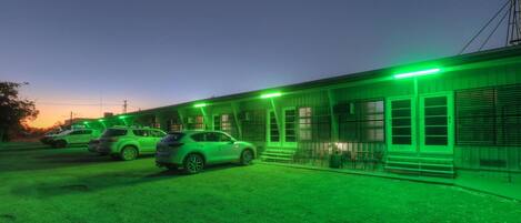 A building with a porch and a car parked in front.