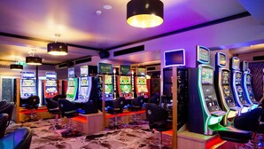 A gaming area with multiple arcade machines and several chairs. - Carriers Arms Hotel (Maryborough)