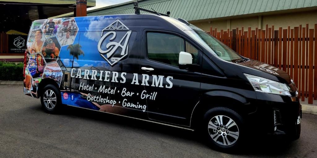 Una camioneta negra con la marca 'CARRIERS ARMS' que indica hotel, motel, bar, parrilla, Bottlestead y juegos.