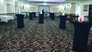 A conference room with a patterned carpet, black tables, and a chandelier. - Carriers Arms Hotel (Maryborough)
