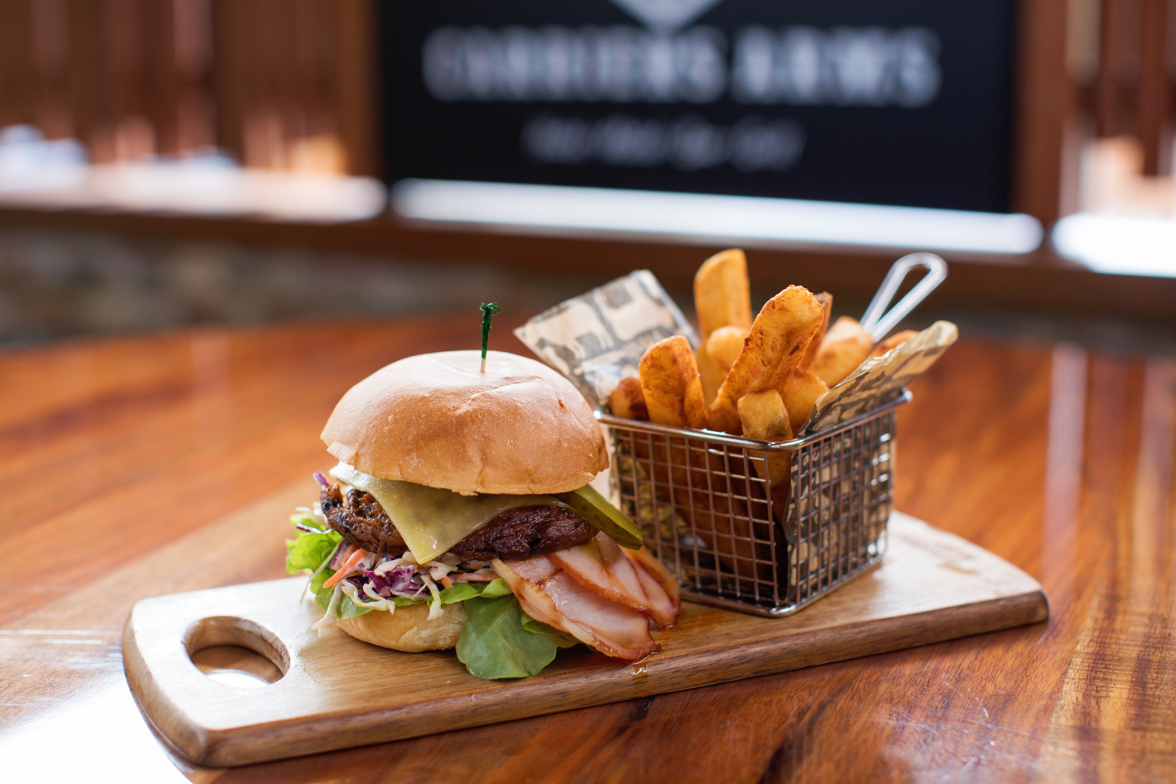 Una hamburguesa con papas fritas sobre una tabla de madera.