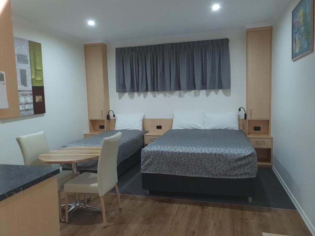 Hotellihuone, jossa on sänky, työpöytä ja tuoli.