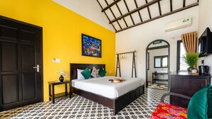 Una habitación con cama, mesita de noche, espejo, cómoda y ventana con cortinas.