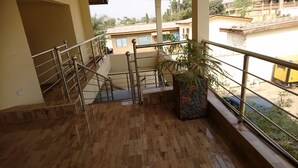 A multi-level building with a wooden floor, metal railings, and a potted plant.
