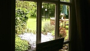 A window with a view of a garden and outdoor seating area. - The Coachman Inn (Scarborough)
