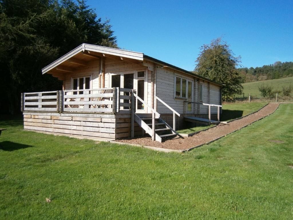 A wooden cabin with a porch and a staircase leading to the entrance.