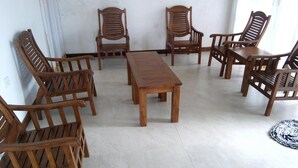 A room with a wooden dining table surrounded by six wooden chairs. - Amaya View Guest Inn (Haputhale)