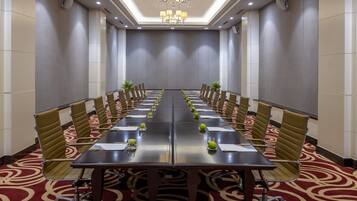 A conference room with a long table, chairs, and a chandelier.