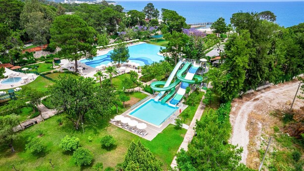 Un complexe hôtelier doté de plusieurs piscines, d’un toboggan aquatique et d’une végétation luxuriante.