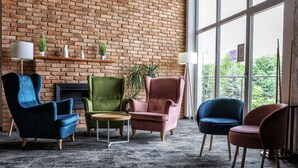 A room with a brick wall, large windows, and four chairs. - Jan Sander Hotel (Aleksandrow Lodzki)
