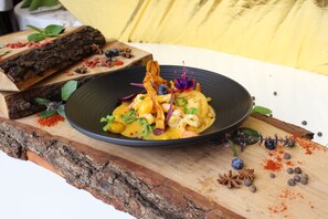A dish with seafood and vegetables on a wooden board. - Jan Sander Hotel (Aleksandrow Lodzki)