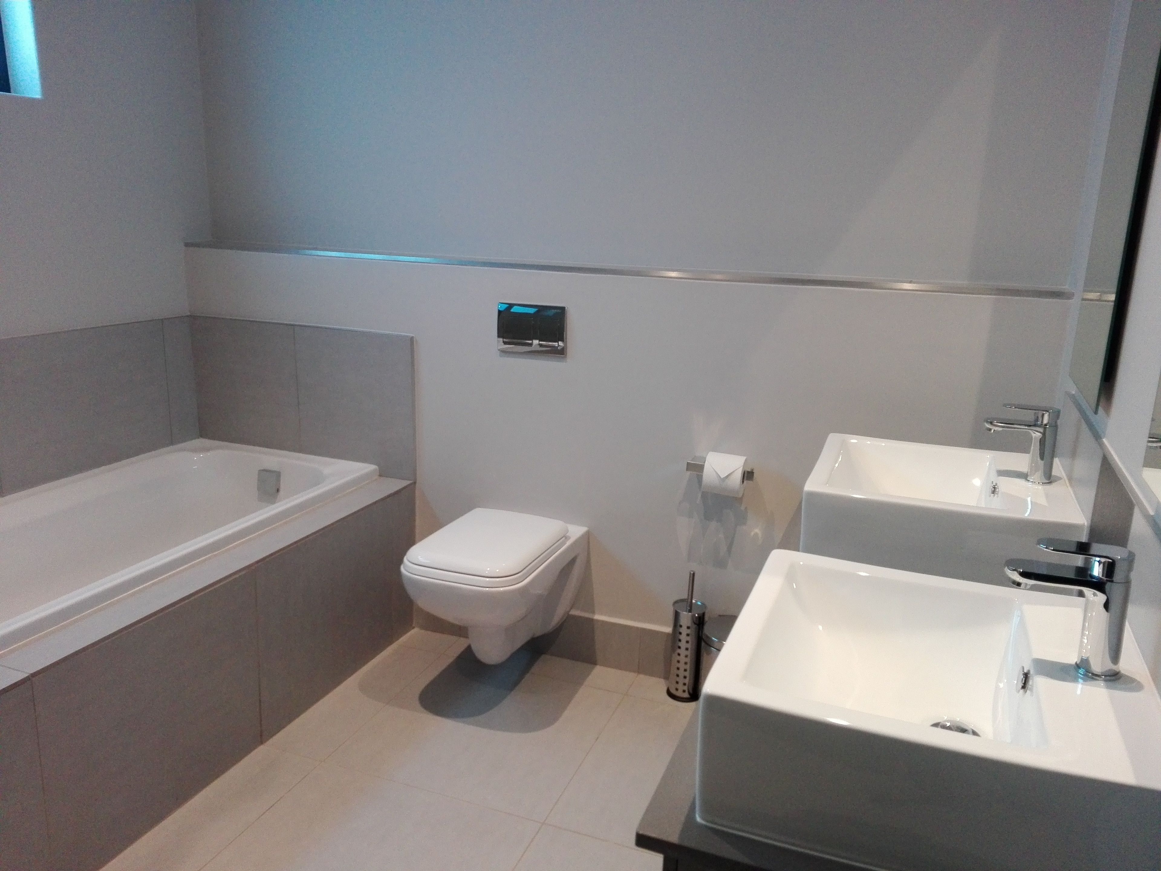 A modern bathroom with a bathtub, toilet, and sink.