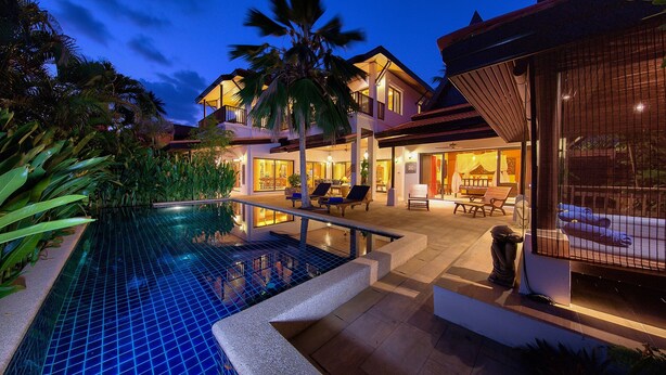 Um resort moderno com piscina, área de estar externa e um pátio bem iluminado.