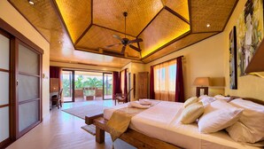Um quarto espaçoso com uma cama grande, cabeceira de madeira e um ventilador de teto.