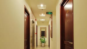 A hotel hallway with a tiled floor, wooden doors, and a potted plant. - Hotel Kim Yen (Ho Chi Minh City)