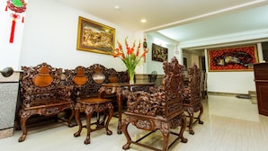 A traditional dining area with ornate wooden furniture, a vase of flowers, and framed artwork on the walls. - Hotel Kim Yen (Ho Chi Minh City)