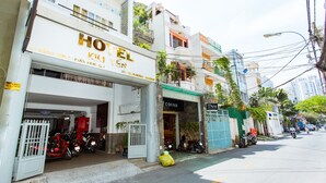A hotel with a signboard, a coffee shop, and parked motorcycles. - Hotel Kim Yen (Ho Chi Minh City)