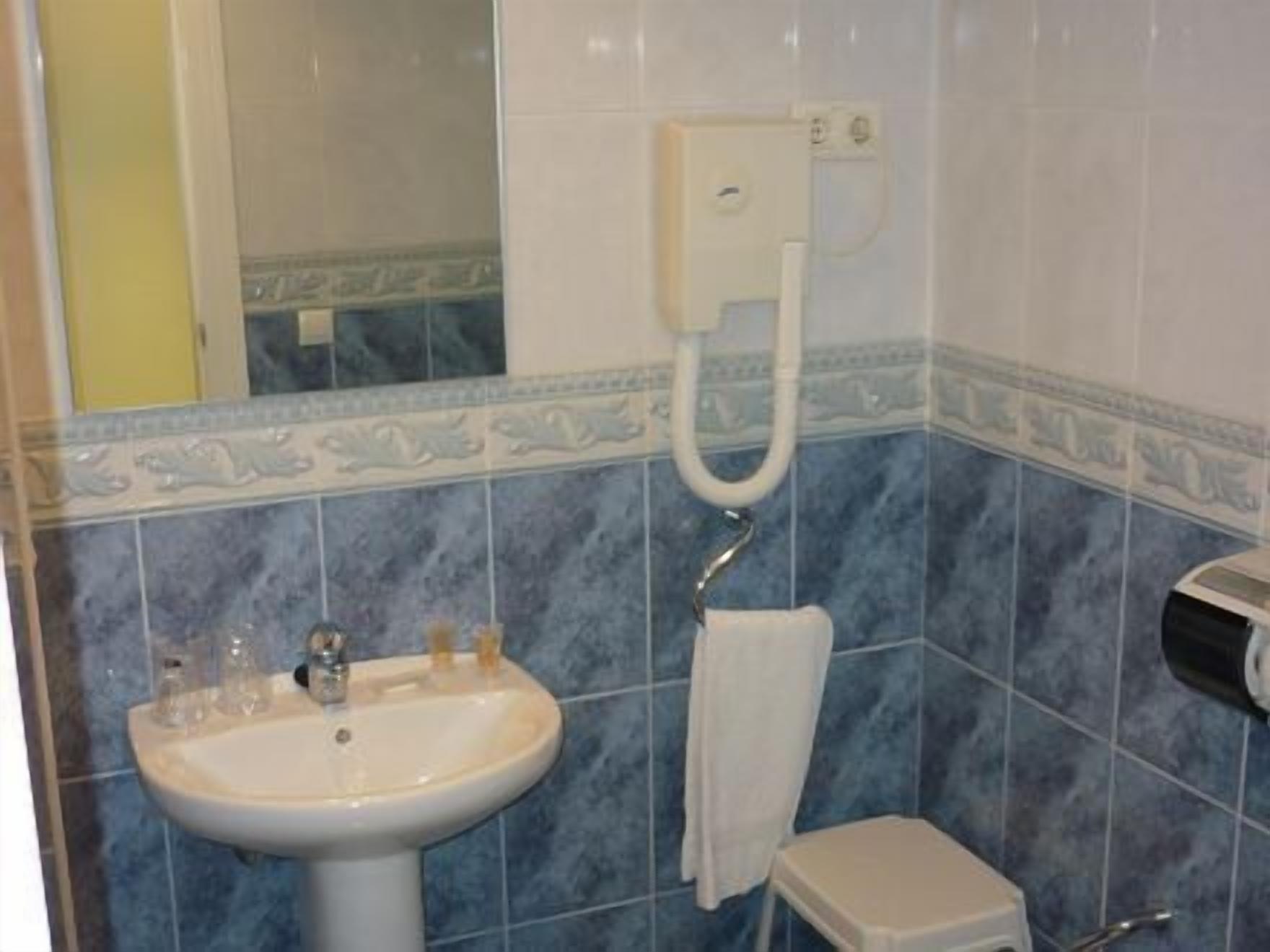 Une salle de bain avec un lavabo, un porte-serviettes et des toilettes.