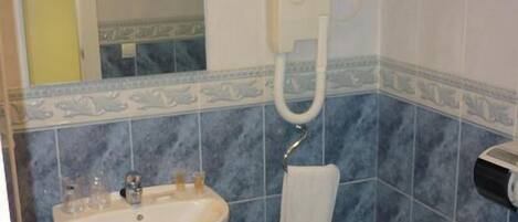 A bathroom with a sink, a towel rack, and a toilet.