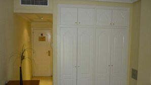 A hallway with a white double door, a wooden desk, and a plant. - Hotel Tuto (Torrevieja)