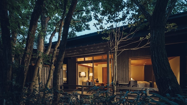 A modern building with large glass windows, surrounded by trees. - Hoshino Resorts KAI Aso (Kokonoe)