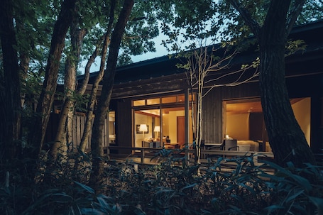 A modern building with large glass windows, surrounded by trees.