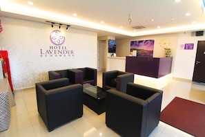 A hotel lobby with a reception desk, seating area, and a wall-mounted clock. - Hotel Lavender Senawang (Seremban)