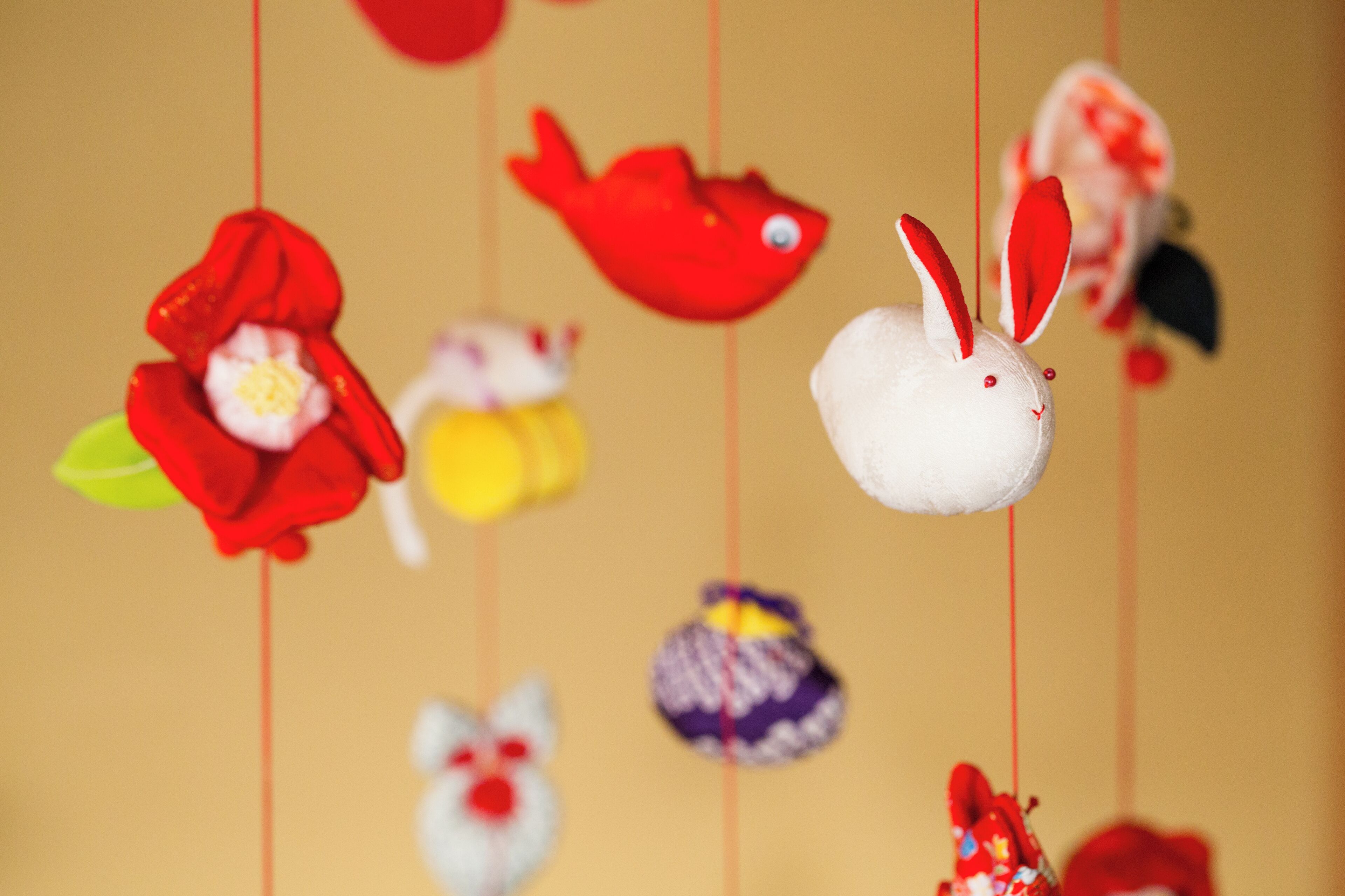 A collection of hanging decorations including a red fish, a white rabbit, and various other colorful items.
