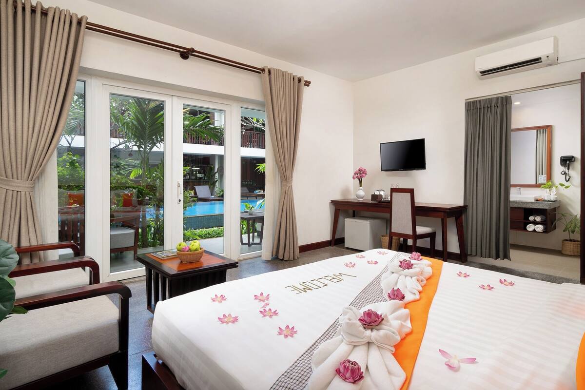Ein Hotelzimmer mit Bett, Schreibtisch, Stuhl, Fernseher und Badezimmer.