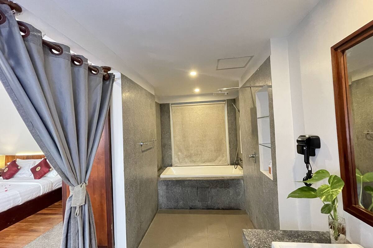 honeymoon suite with balcony pool view | bathroom | designer toiletries, hair dryer, bathrobes, slippers