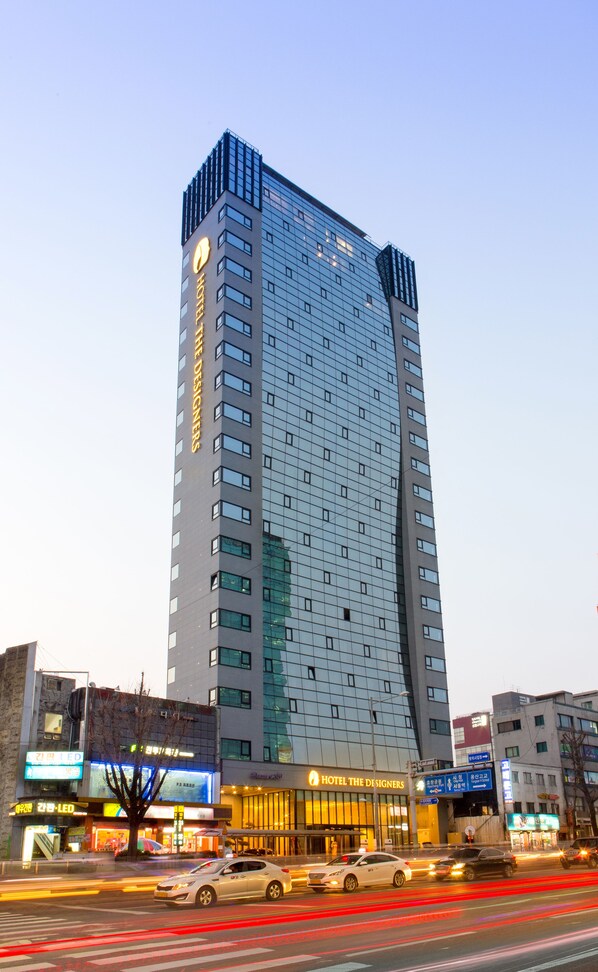Een modern hotel met een opvallende, gebogen gevel, meerdere verdiepingen en een groot bord bovenaan.