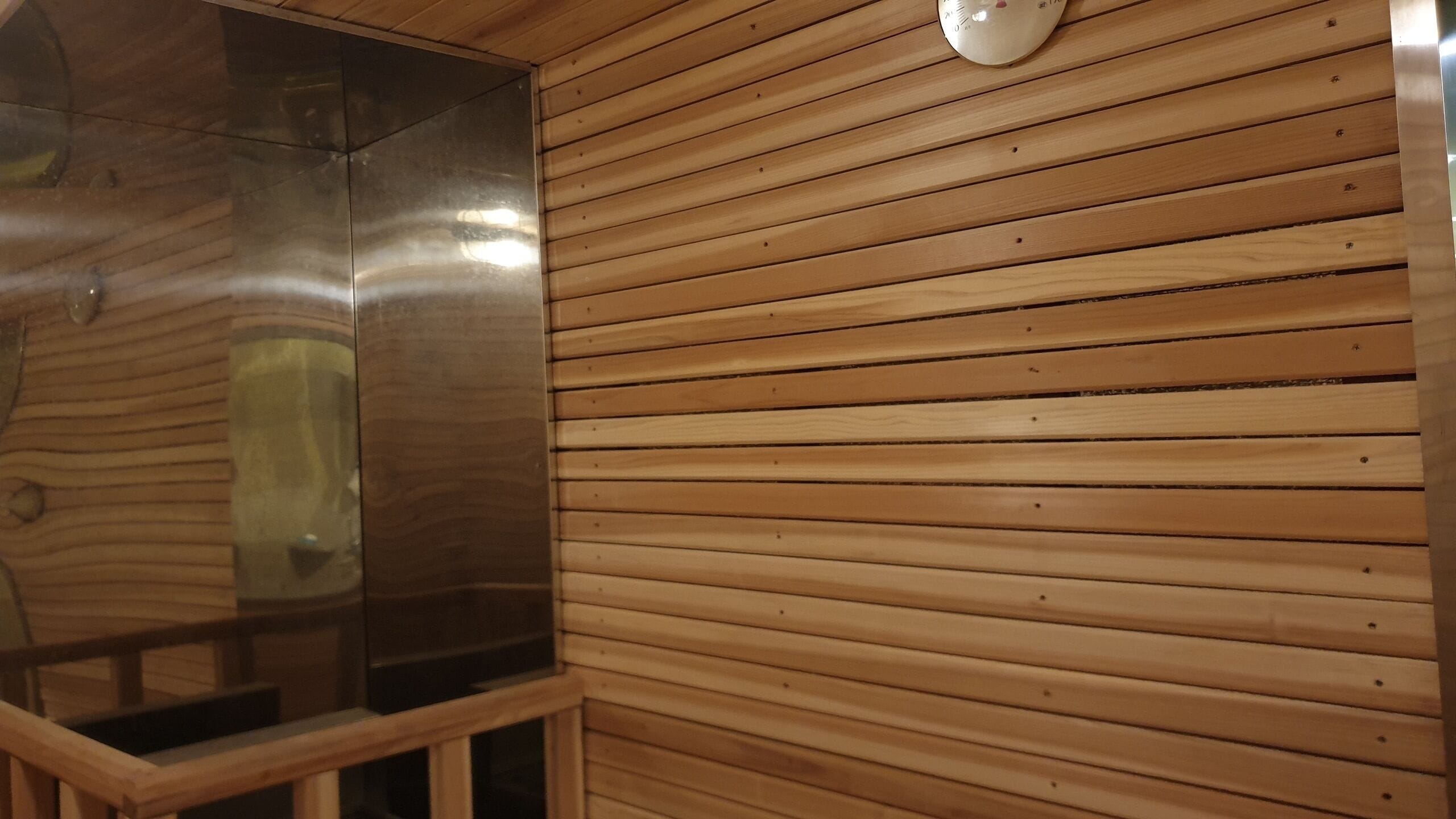 A wooden interior with a glass partition and a ceiling-mounted light fixture.