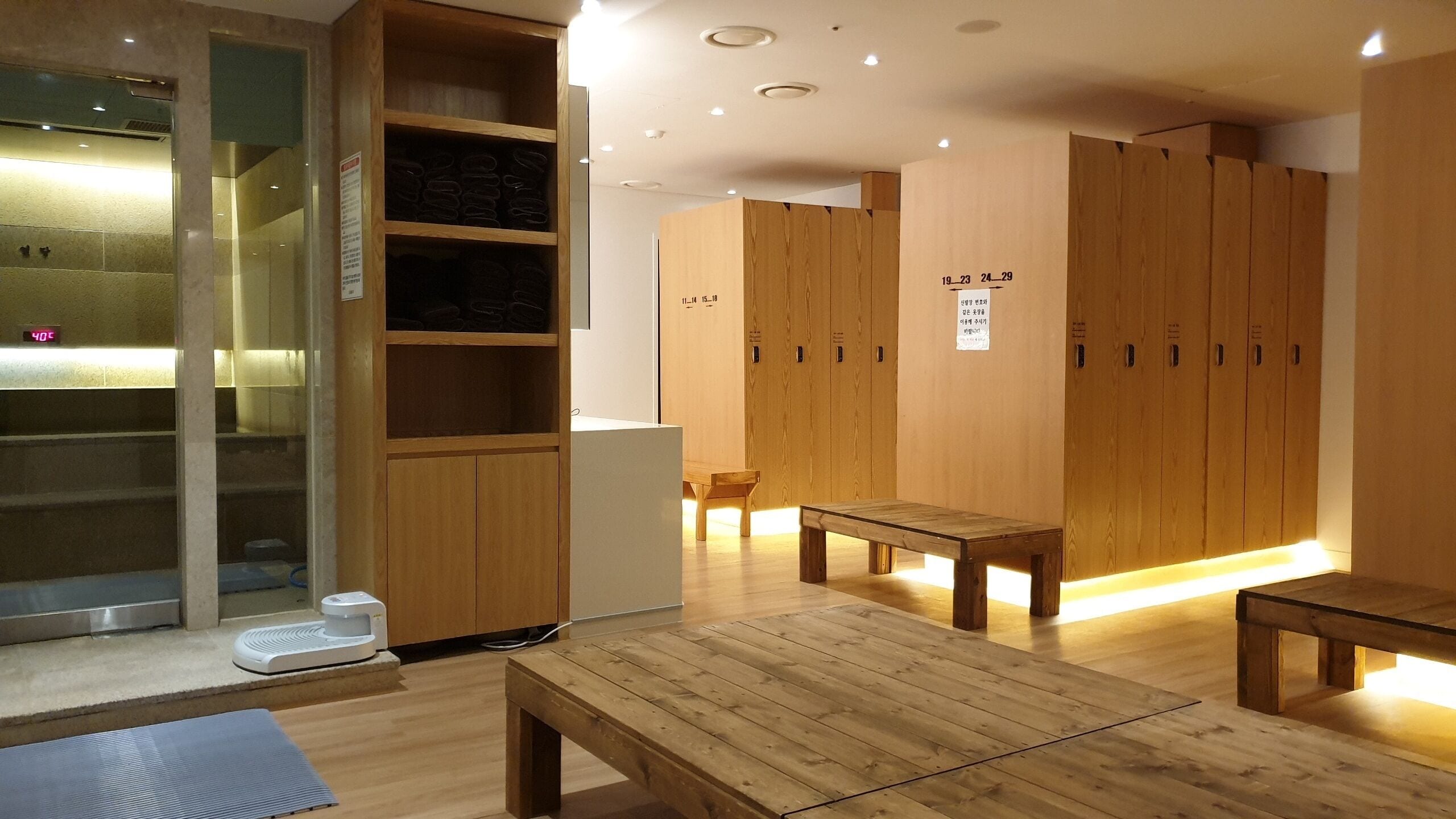 Vestuario de madera con bancos y una silla de masaje.