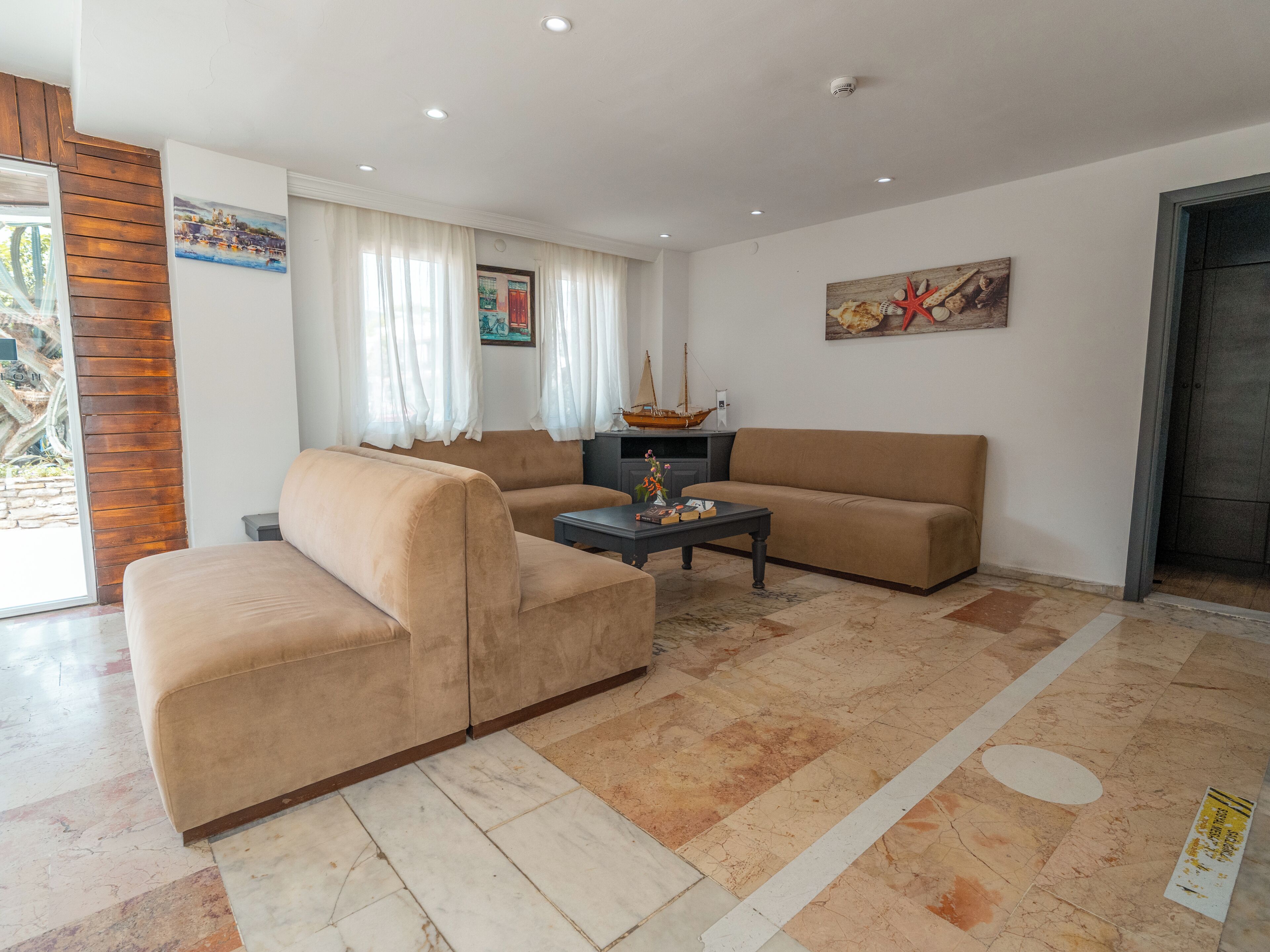 A living room with a beige sofa, a coffee table, and a painting on the wall.