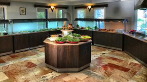 A buffet setup with various food items and a central island. - Otel Atrium (Bodrum)