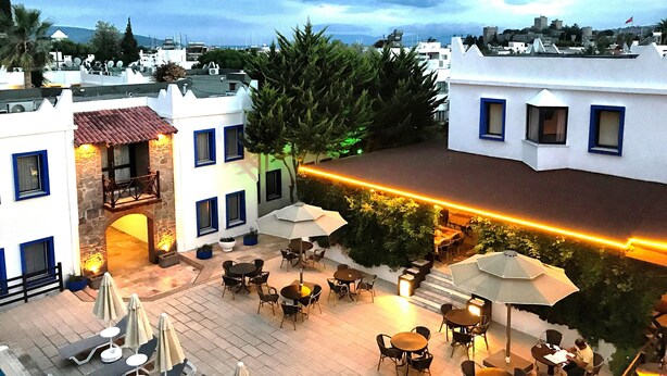 Terraza en la azotea con mobiliario exterior y vistas a la ciudad.
