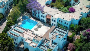 Zona residencial con varios edificios, piscina y abundante vegetación.